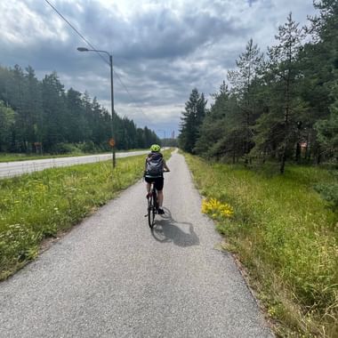 Eine Fahrradfahrerin fährt auf einem separaten Fahrradweg von Turku nach Nauvo in Finnland