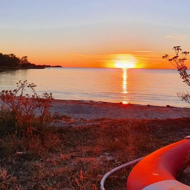 Ein orange roter Sonnenuntergang am Meer in Burgsvik auf Gotland.