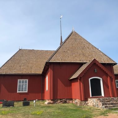 Die rote Kirche aus Holz von Houtskär, Finnland ist abgebildet.