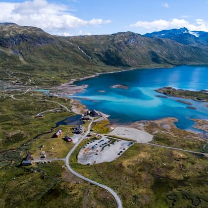 Eidsbugarden, au bord du lac Bygdin, scintille d'un bleu clair dans le paysage verdoyant de la Norvège.
