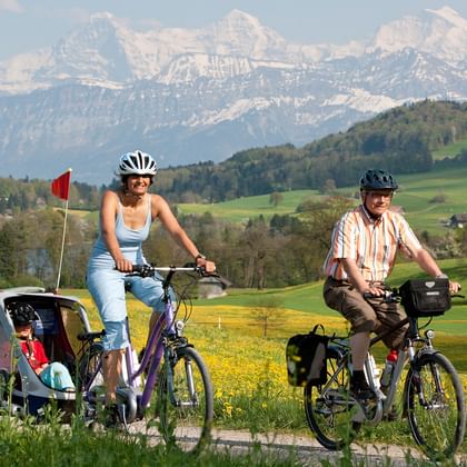 Deux cyclistes avec un e-bike Flyer et une remorque pour enfants, sur la route naturelle de la Herzroute.