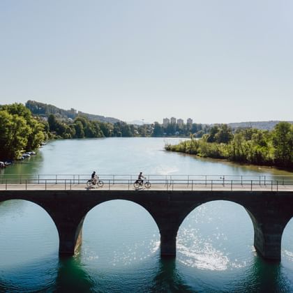 Zwei Velofahrer überqueren die Aare auf einer Brücke bei Bern.