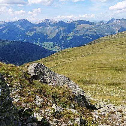 Stein mit aufgedrucktem Steinbock. Wunderschöner Ausblick auf die Bergkette im Kanton Graubünden