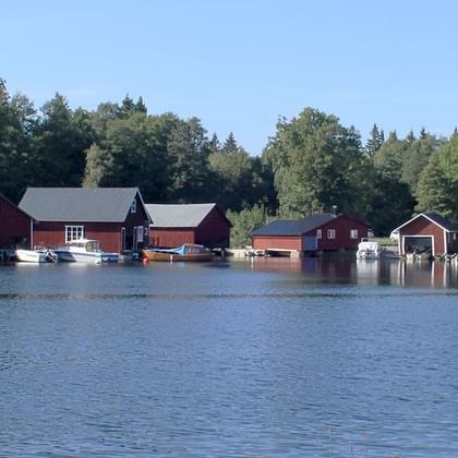 In der Mitte die See an deren Ufer die typischen Schwedischen Bootshäuschen stehen, die teilweise auch als Sauna benutzt werden.