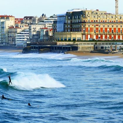 Surfer in den tobenden Wellen der Küste vor der Stadt Biarritz