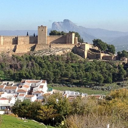 Eine Burg mit Kirche auf einem leicht erhöten Berg. Darunter befindet sich Antequera in Andalusien.