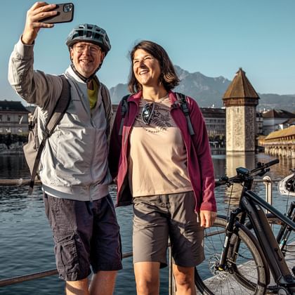 A couple pause for a selfie in front of the Chapel Bridge in Lucerne.