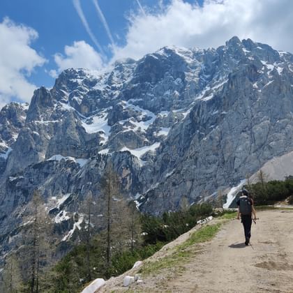 Eine Frau wandert umgeben von massiven Bergen in Slowenien.