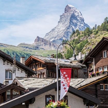 Zermatt village with Matterhorn peak Traditional Swiss chalets in Zermatt with the iconic pyramid-shaped Matterhorn mountain peak rising dramatically in the background.