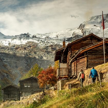Mountain huts near Saas Fee are visited by a hiking couple.
