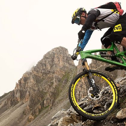 Brave mountain biker in full gear on a rocky downhill.