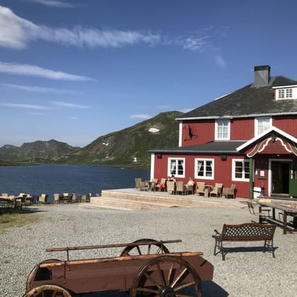 Ein typisches rotes norwegisches Haus steht am Ufer vom Bygdin See.