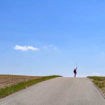 Wanderer auf einer Anhöhe mit weitem Himmel