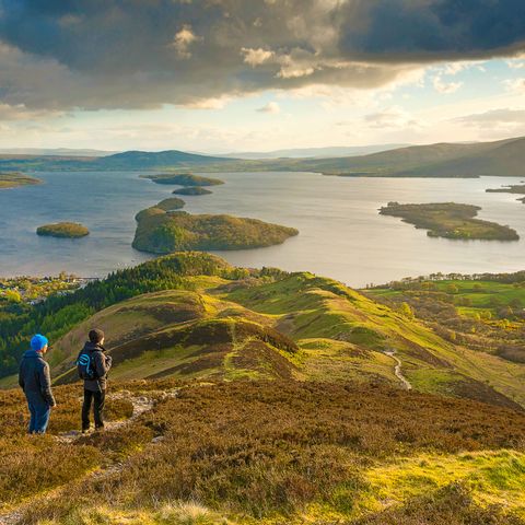 Deux randonneurs contemplent le lac Loch Lomond en Écosse