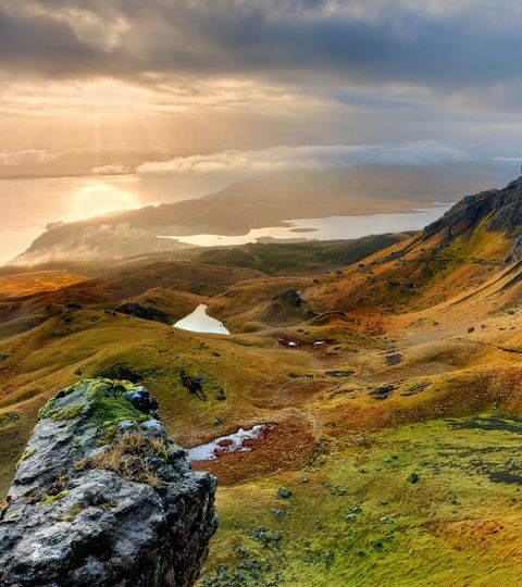 Der Sonnenuntergang lässt das Meer und die Landschaft Schottlands goldig leuchten.