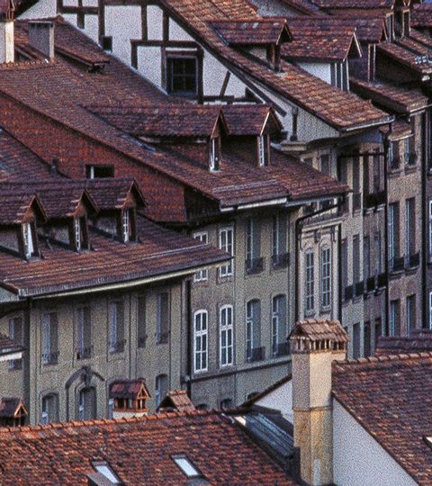 Ein Bild der Stadt Bern aus der Vogelperspektive. Verschiedene Dächer von alten Häusern die aneinader gebaut sind.