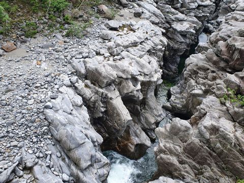 Ein Fluss schlängelt sich durch speziell geformte helle Felsen. 