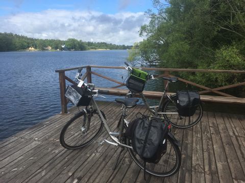 Zwei mit Fahrradtaschen beladene Fahrräder auf einem Steg am See
