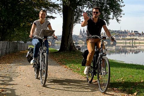 Zwei Radfahrer fahren am Ufer der Loire in Frankreich entlang.