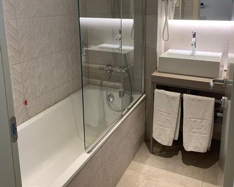 Eine Badewanne und ein Lavabo im Hotel in Triest. 