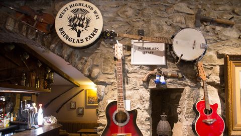 bar accueillant avec guitares sur le mur de pierre