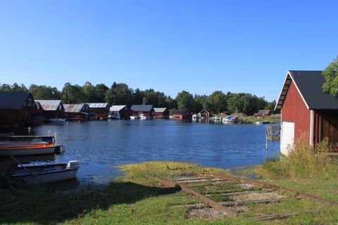 Mehrere Schwedenhäuser stehen an einem See in Schweden. Aktivferien mit Eurotrek.