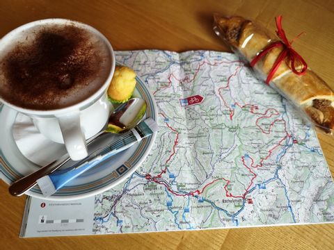 Die Karte bei einem feinen Kaffee und einem Nussgipfel lesen.