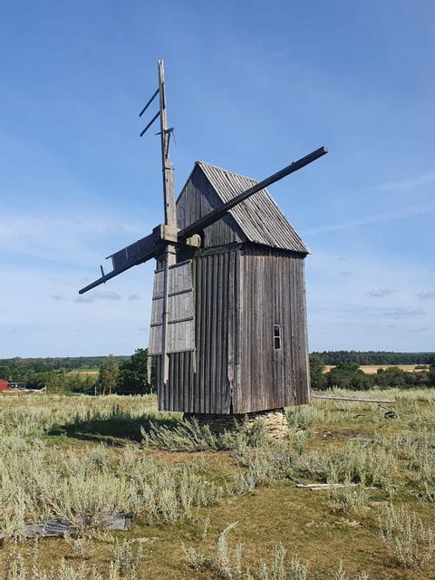 Eine Holzmühle steht auf einem Feld in Gotland. 