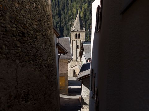 Kirchturm auf dem Via Francigena durch einen Spalt zwischen zwei Häusern fotografiert, auf dem Pilgerweg nach Rom.