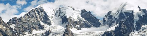 Ein Bergpanorama des Berninapasses in Graubünden. Schneebedeckte Bergspitzen. 