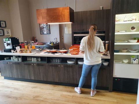 Eine Frau bedient sich am Frühstücksbuffet im Hotel Home in Locarno. 
