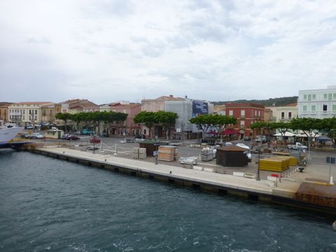 Viele bunte Häuser stehen an der Promenade auf Sardinien.