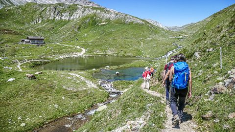 Un groupe de randonneurs se dirige vers un lac de montagne dans le Val d'Uina, dans le canton des Grisons. 