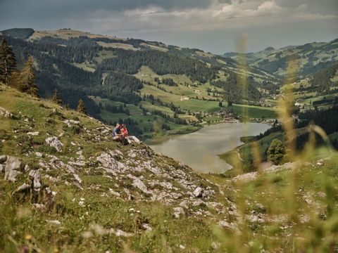 Un couple fait une pause sur une prairie rocailleuse à Fribourg, au-dessus du Lac Noir.