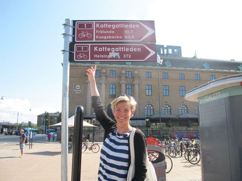 Eine Frau steht vor einem Wegweiser des Kattegattledens in Schweden.