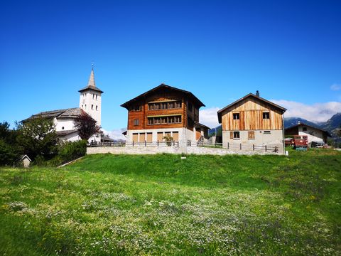 kleines Dorf mit Kirche inmitten einer Berglandschaft