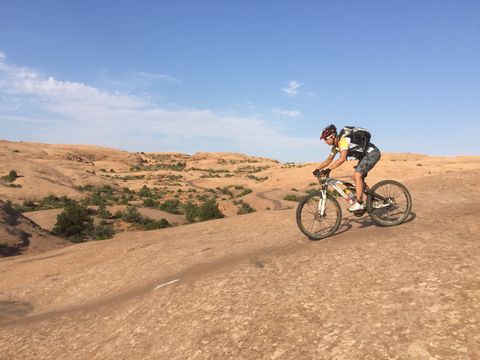 Eveline, collaboratrice d'Eurotrek, pédale sur un vélo à travers des paysages de sable immaculés.