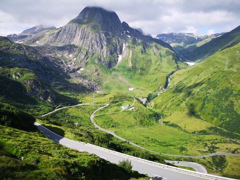 Nufenenpass umgeben von grünen Wiesen und Bergen. Rennvelo Oberwallis. Veloferien mit Eurotrek.