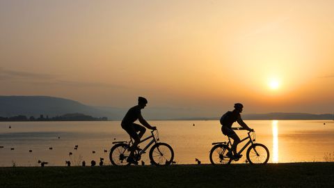 Cyclist in front of a lake at sunset