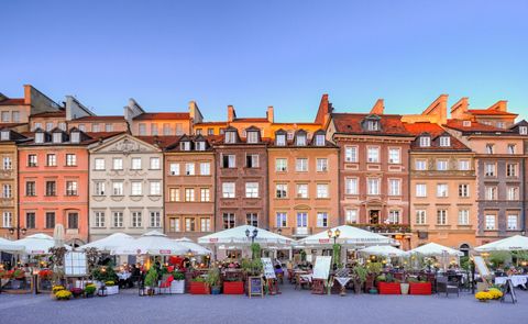 Ein Markt mit vielen Ständen unter quadratischen Sonnenschirmen, vor den Häusern der Altstadt.