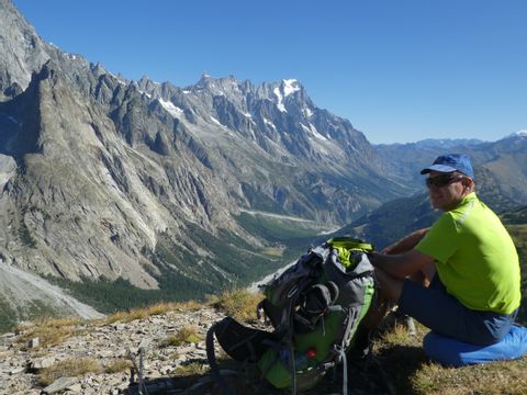 Wanderer geniesst die atemberaubende Aussicht auf eine Gebirgskette. Tour de Mont Blanc West. Wanderferien mit Eurotrek.