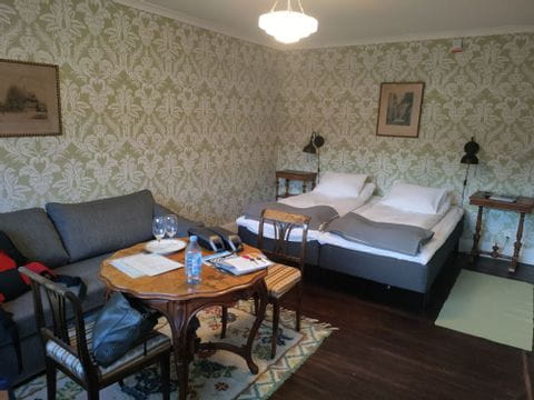 Ein komfortables Hotelzimmer mit Doppelbett und grüner Tapete. 