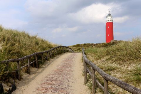 Strandweg mit einem Leuchtturm. Aktivferien mit Eurotrek.