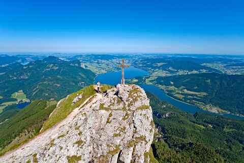 Summit cross at the mountain Schafberg with view to Lake Mondsee