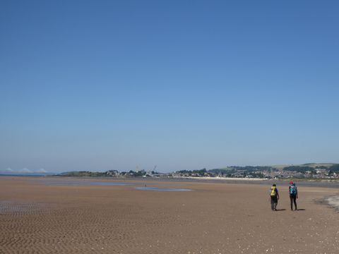 Zwei wanderer laufen bei Ebbe der Küste entlang.