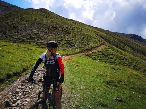Mountainbikefahrerin auf einem Pfad in einer kargen Landschaft