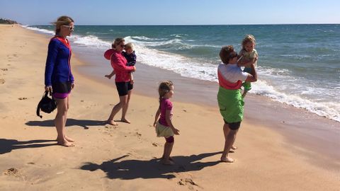 Die Familien geniessen den Sandstrand am Meer. 