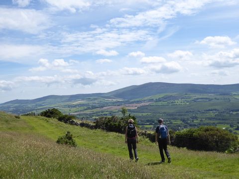 Zwei Wanderer geniessen das weitläufige Panorama auf dem Wicklow Way in Irland.
