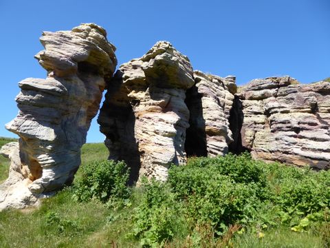 Grosse Felsen sind vom Wind geschliffen und stehen an der Küstenwanderung in Schottland.