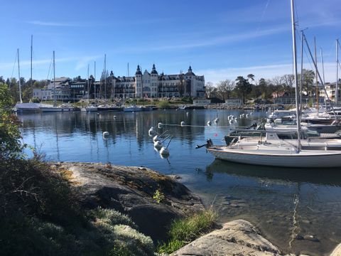 Ein Segeyachthafen mit vielen Booten und ein luxuriöses Gebäude im Hintergrund in Schweden.